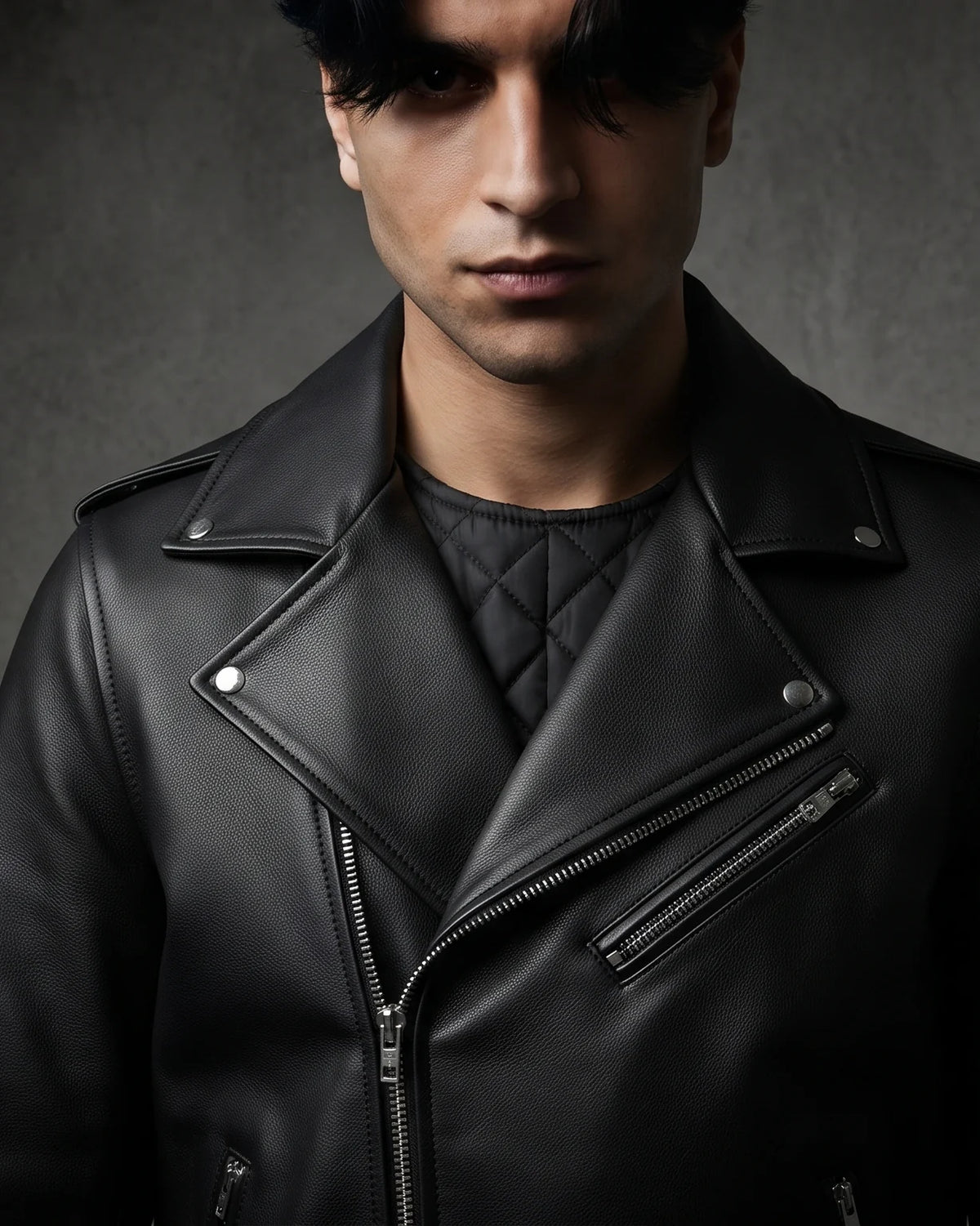 Zaryash black faux leather biker jacket, front close-up of lapels, zips and studs